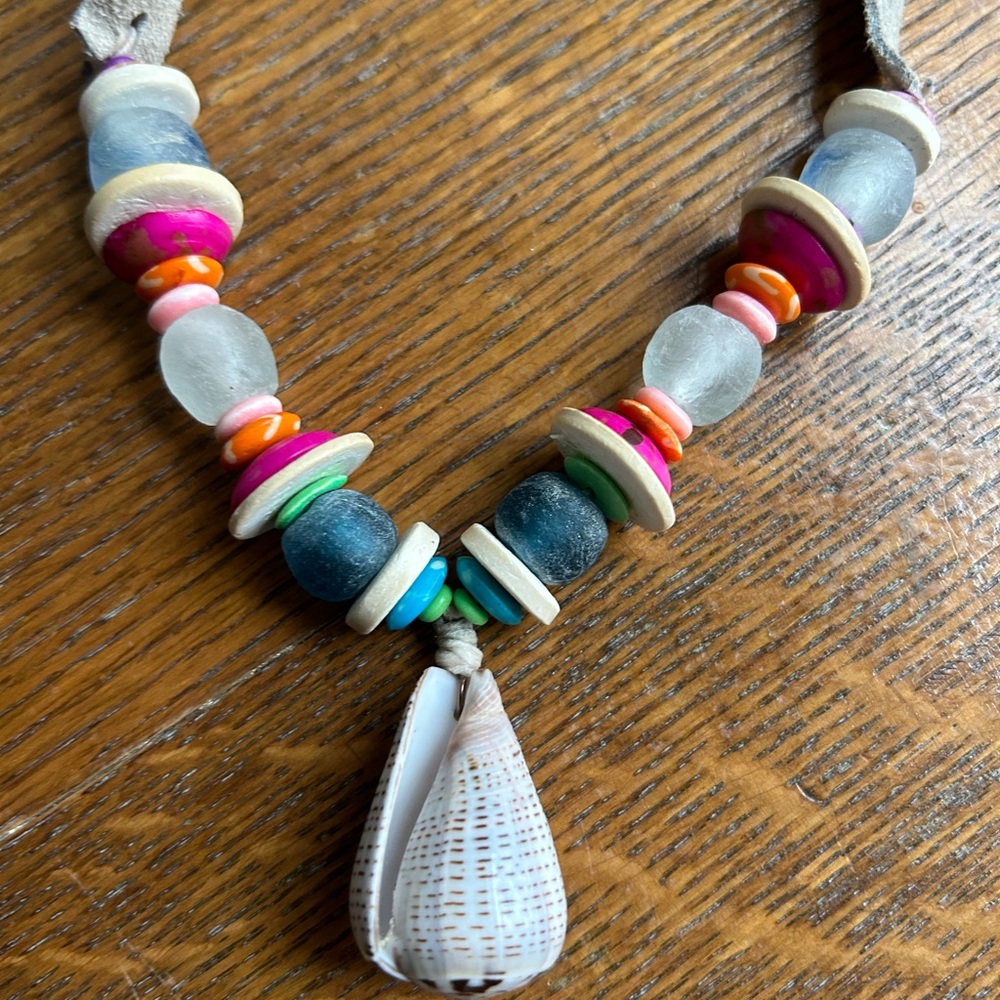 Multi colored Twine and Twig shell necklace with grey suede.